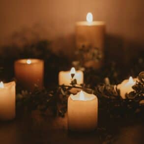 Several candles intertwined with foliage
