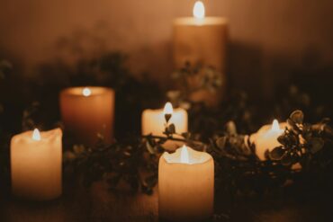 Several candles intertwined with foliage