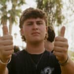 Older male teen gives a double thumbs up