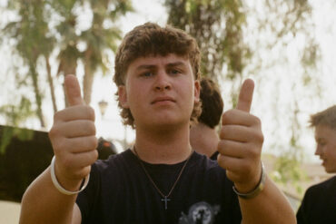 Older male teen gives a double thumbs up