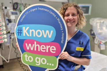 nurse holding 'know where to go' sign