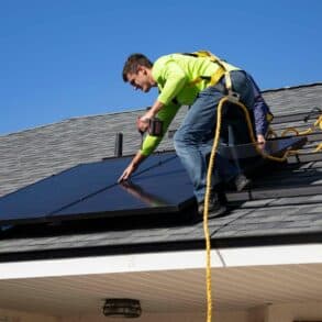 solar panel installer on the roof of a house