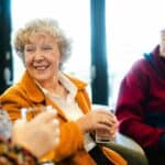 three older people drinking coffee and chatting