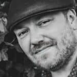 Black and white photo of Ben Allman with his guitar