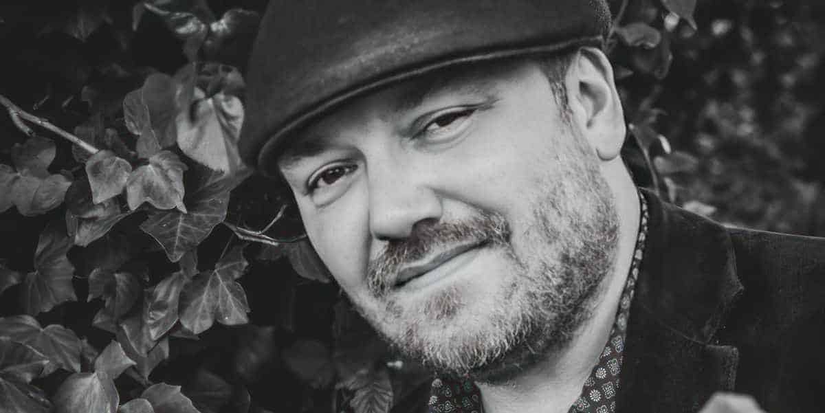 Black and white photo of Ben Allman with his guitar