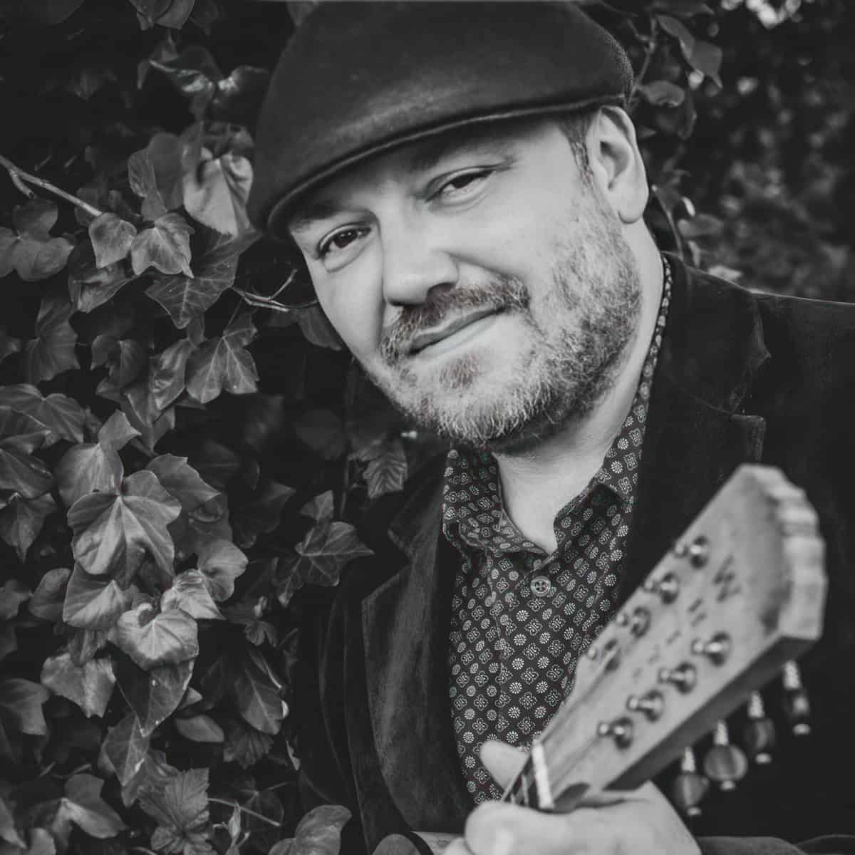 Black and white photo of Ben Allman with his guitar