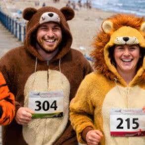 Four people in bear fancy dress running along the seafront