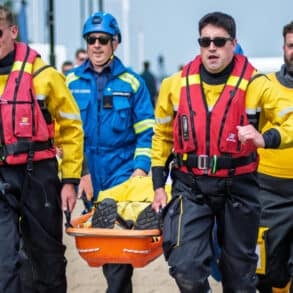 RNLI crew carry a dummy along the seafront