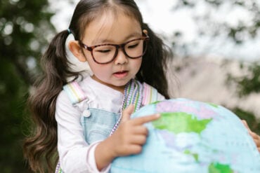 child looking at a globe