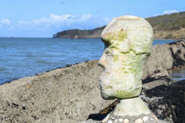 hideous head sculpture on Bouldnor Beach