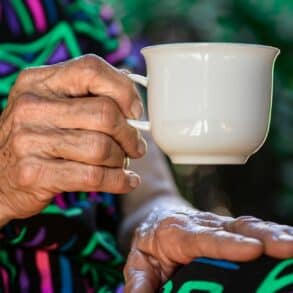 older person holding a cup of tea