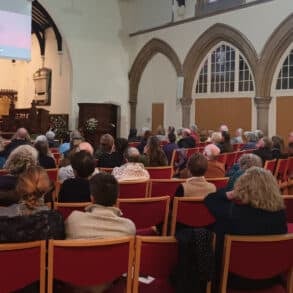 people seated in st catherines church attending the screening of the emergency briefing