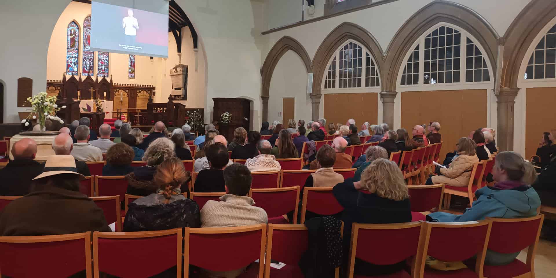 people seated in st catherines church attending the screening of the emergency briefing