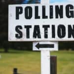 polling station sign by a park