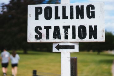 polling station sign by a park