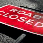 road closed sign laying flat on the road