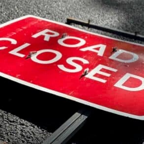road closed sign laying flat on the road