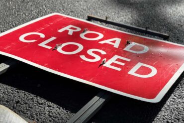 road closed sign laying flat on the road