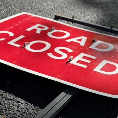 road closed sign laying flat on the road
