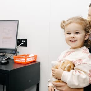 Mother and child sitting with GP