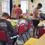 Young peole and paretns taking part in junk modelling at the library