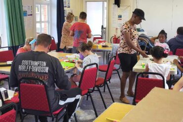 Young peole and paretns taking part in junk modelling at the library