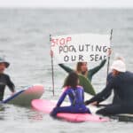 Protesters in the sea for the Paddle Out Protest