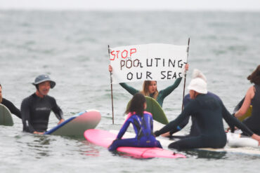 Protesters in the sea for the Paddle Out Protest