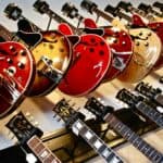 Rows of guitars hanging on a wall in a shop