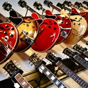 Rows of guitars hanging on a wall in a shop
