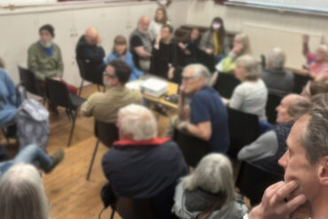 people attending the emergency climate briefing screening blurred background