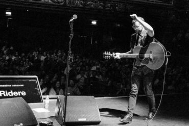 tom bright performimg on stage in front of a large audience
