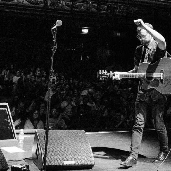 tom bright performimg on stage in front of a large audience
