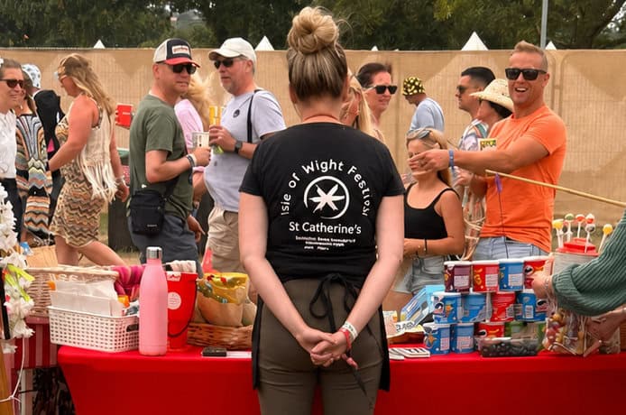 Person manning the tuck shop stall at Isle of Wight Festival