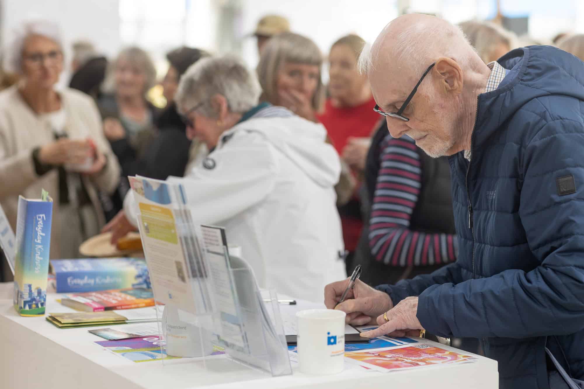 People looking at photos at the Ronson Reunited event