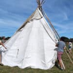 Several people involved with erecting the teepee in the field