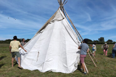 Several people involved with erecting the teepee in the field