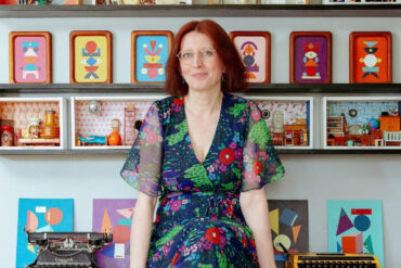 Fran Heath sitting on her desk surrounded by her dire-ramas and vintage typewriters