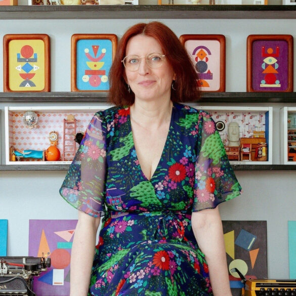 Fran Heath sitting on her desk surrounded by her dire-ramas and vintage typewriters