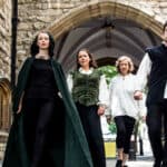 The cast of Impromptu Shakespeare walking through old courtyard