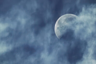 Moon against a blue sky with light clouds