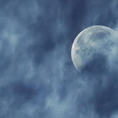 Moon against a blue sky with light clouds