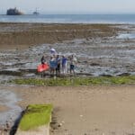 Distance shot of No Poo at the Point campaigners standing where the pipe will come out