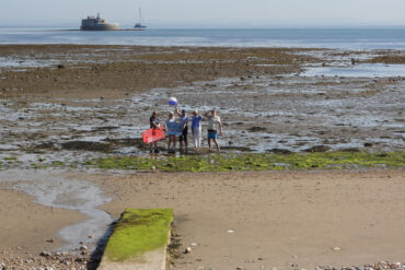 Distance shot of No Poo at the Point campaigners standing where the pipe will come out