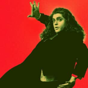 Performer dressed all in black acting as though he is falling against a red background
