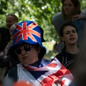 People gathered in London wearing Union Flags as capes