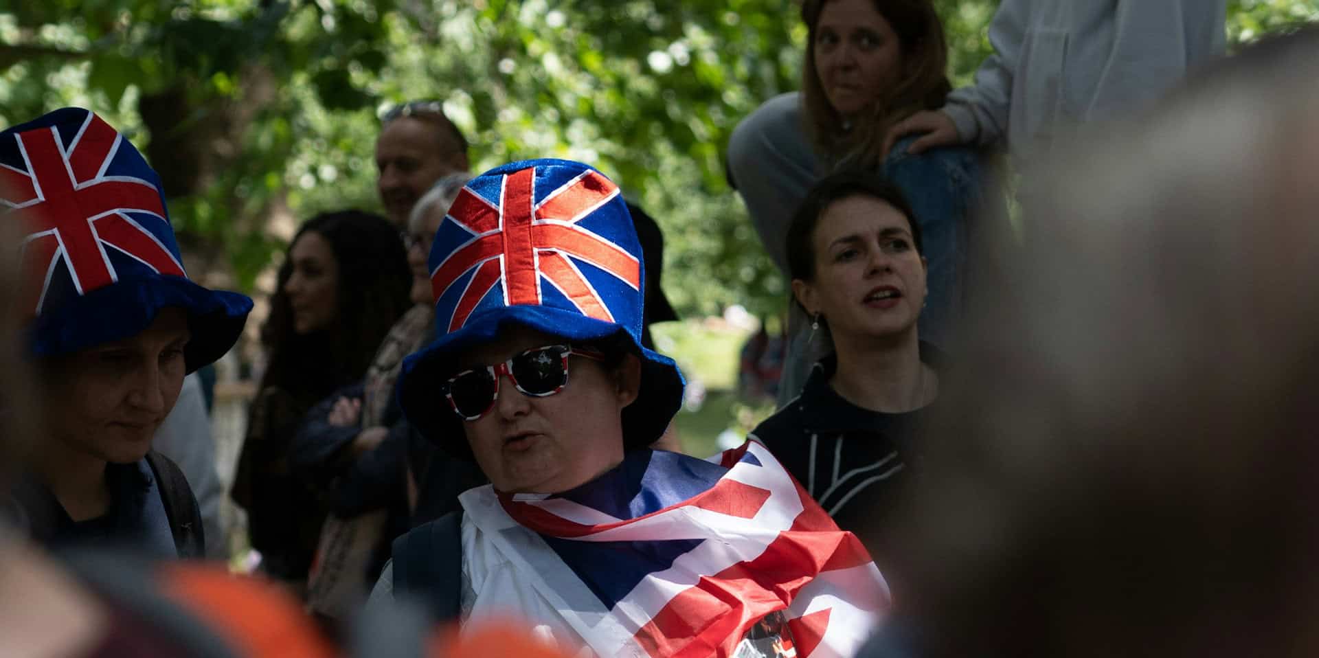 People gathered in London wearing Union Flags as capes