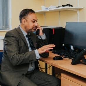 NHS GP sitting at desk on the phone
