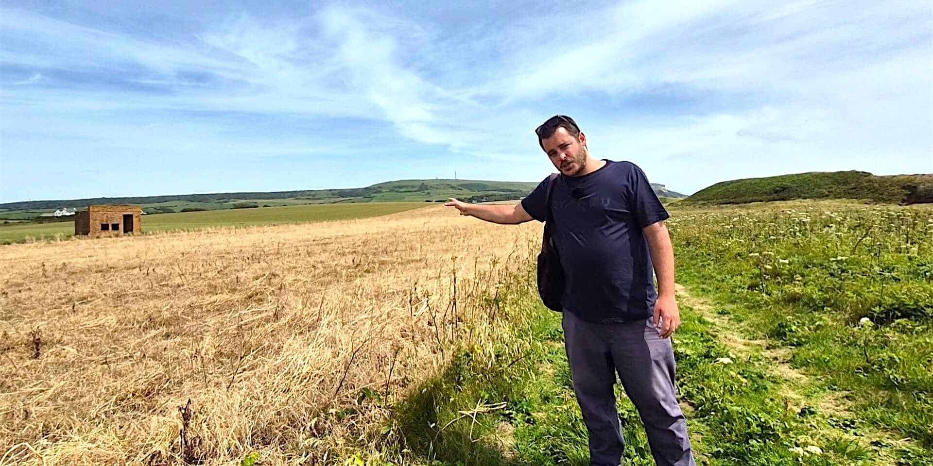 Jack pointing at a pill box structure in the field
