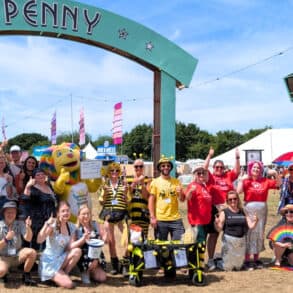 charity members posing for photo at Penny Lane site in Isle of Wight Festival